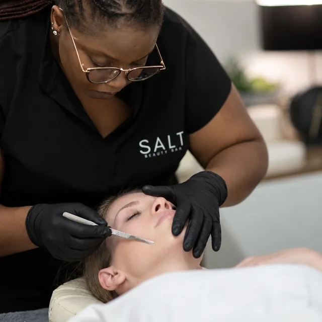 A SALT therapist performing dermaplaning